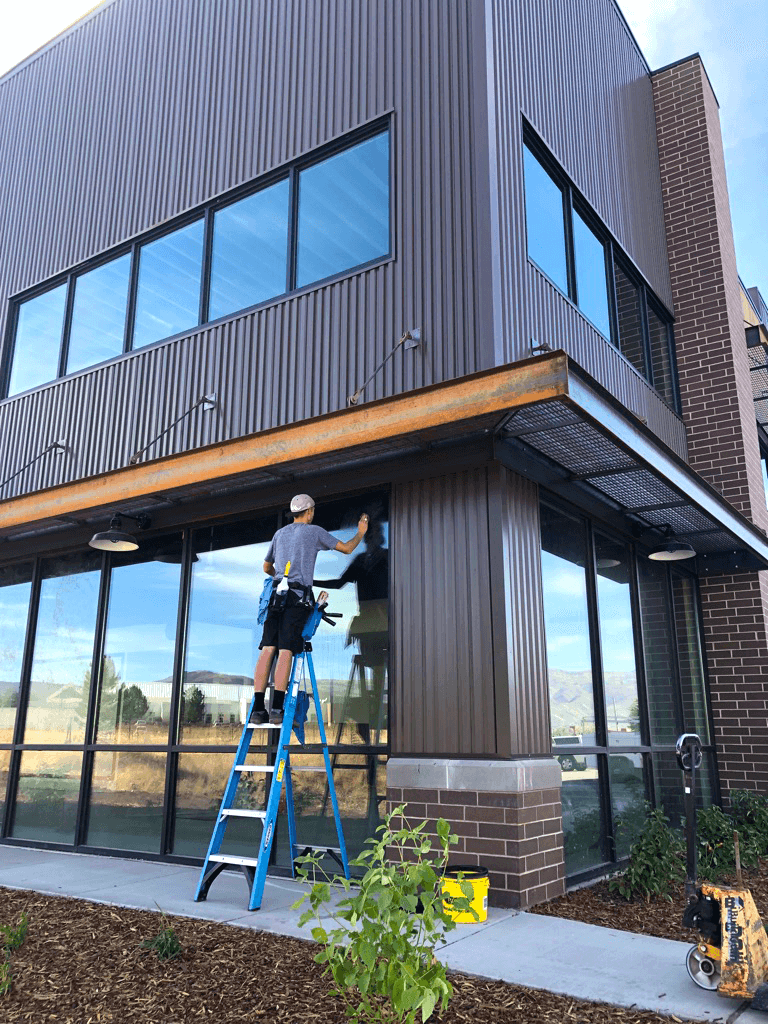 Cleaning windows on a commercial Bountiful building.