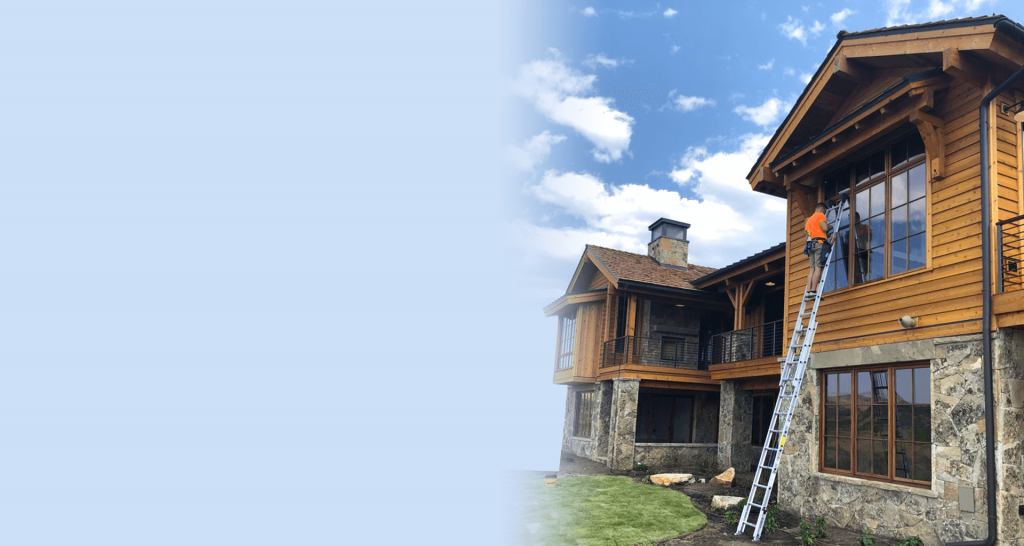 Hero image of cleaning windows on a wood and brick home.