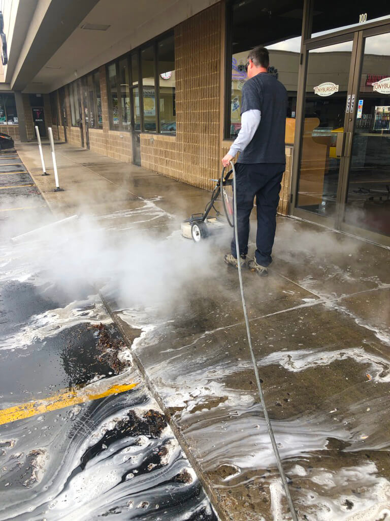 Concrete steam cleaning in front of a retail store in Salt Lake City.