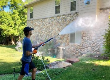 Cleaning siding and brick on a professional house washing.